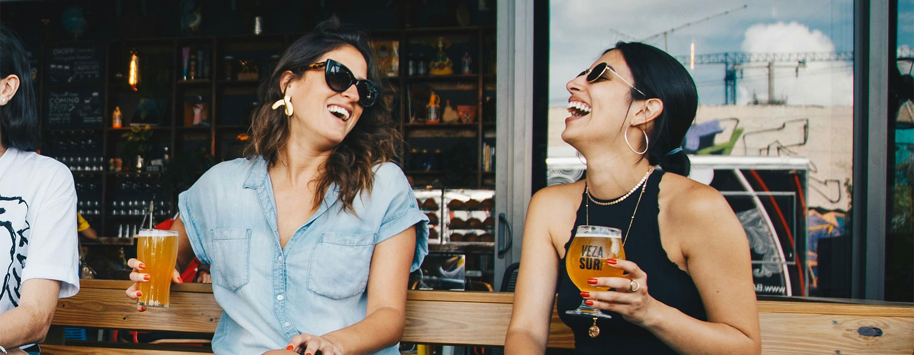 two women holding drinks